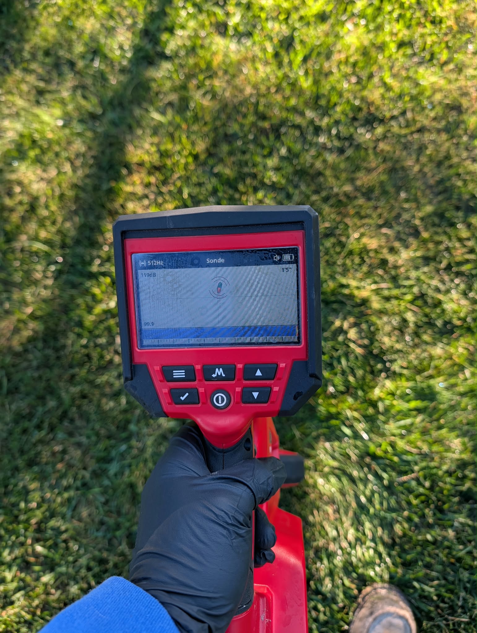 A Drain-Flo technician using a surface locator to trace an underground plumbing line